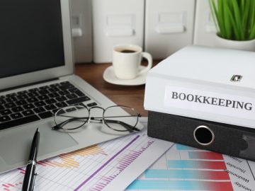 Folders, laptop and documents on desk in office. Bookkeeper's workplace