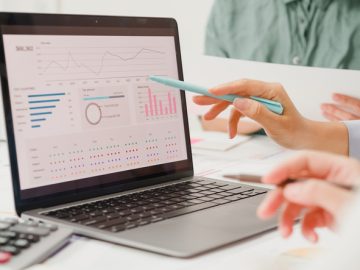 Closeup group of Asian business people meeting discuss project plan and financial results in office. Marketing strategy analysis, stock market trading, financial consultant concept.